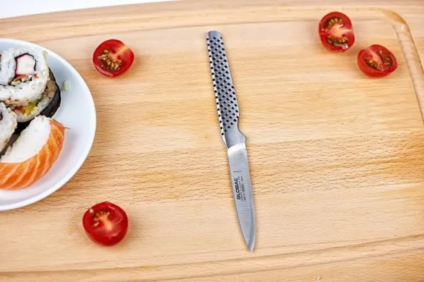 This is a Global paring knife with an 8cm stainless steel blade and a dimpled, ergonomic handle, handcrafted in Japan for excellent balance and precision.