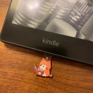 This 7-pack of bookish cat USB-C dust plugs protects your Kindle, iPhone 15, and other devices from dust and dirt while adding a charming touch.