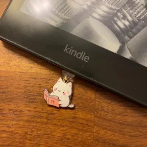 This 7-pack of bookish cat USB-C dust plugs protects your Kindle, iPhone 15, and other devices from dust and dirt while adding a charming touch.