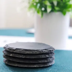 This set of four black slate coasters features a natural, rough-edged design, providing a rustic and stylish surface to protect furniture from drink spills and water rings in your kitchen, living room, or bar area.
