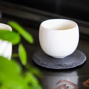 This set of four black slate coasters features a natural, rough-edged design, providing a rustic and stylish surface to protect furniture from drink spills and water rings in your kitchen, living room, or bar area.