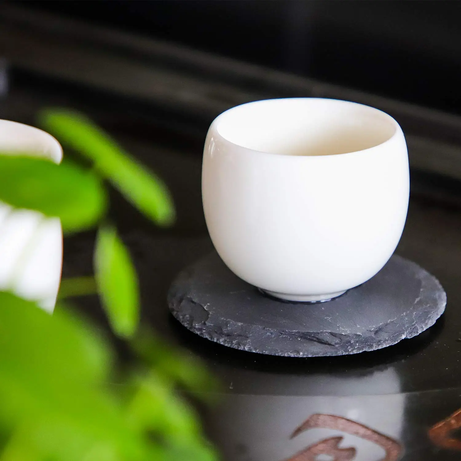 This set of four black slate coasters features a natural, rough-edged design, providing a rustic and stylish surface to protect furniture from drink spills and water rings in your kitchen, living room, or bar area.