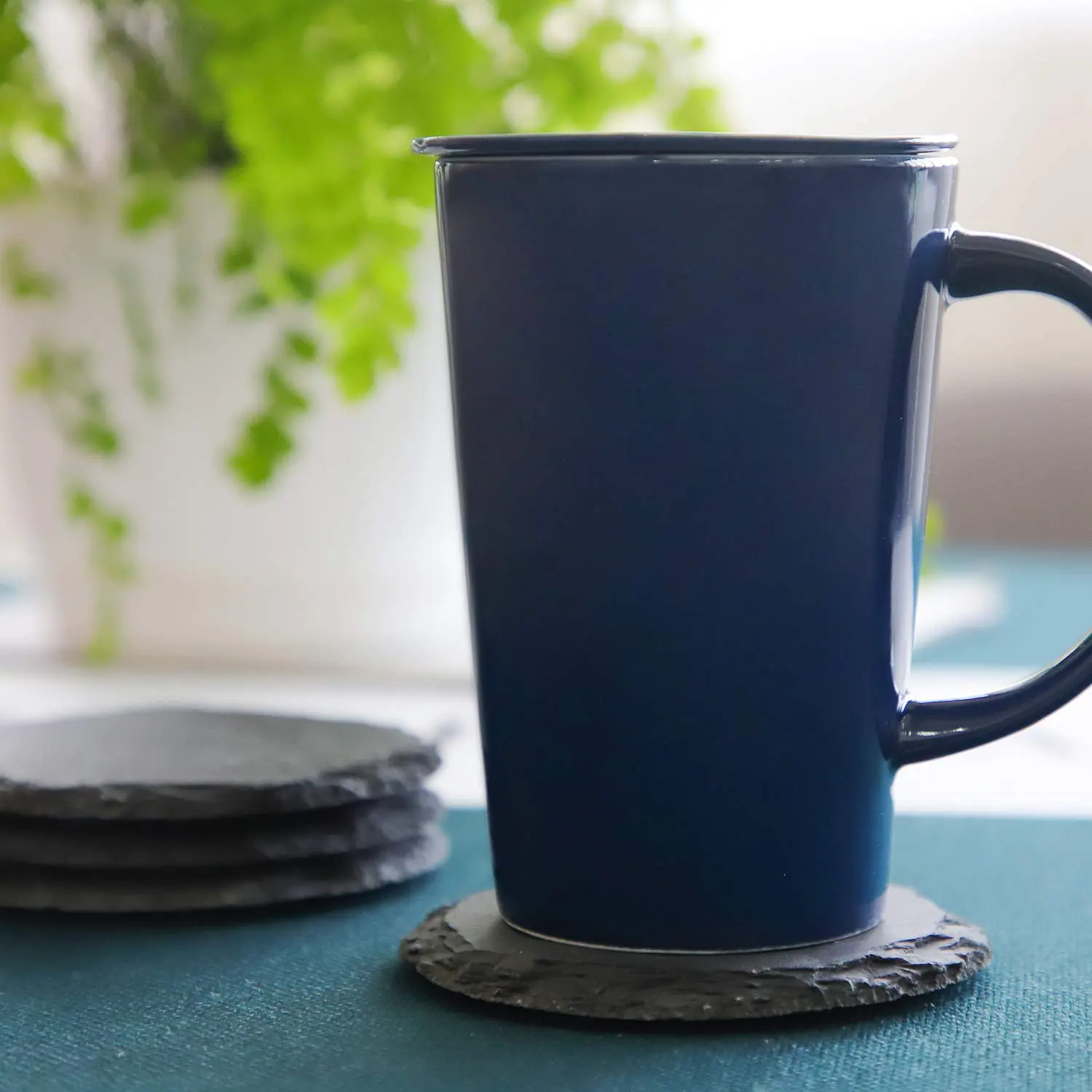 This set of four black slate coasters features a natural, rough-edged design, providing a rustic and stylish surface to protect furniture from drink spills and water rings in your kitchen, living room, or bar area.