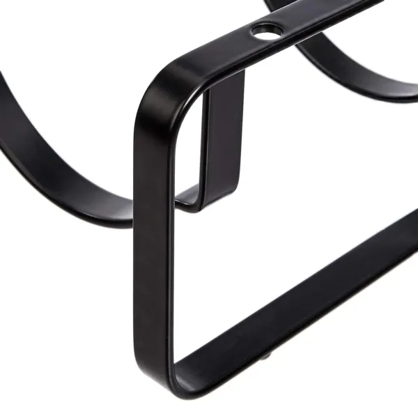 A stackable steel wine rack with a wave design securely holds wine bottles on a tabletop, preventing them from rolling.