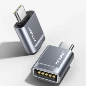 Two grey JSAUX USB-C to USB 3.0 OTG adapters plugged side-by-side into a MacBook Pro, demonstrating the offset design that allows simultaneous use with fast 5Gbps data transfer.