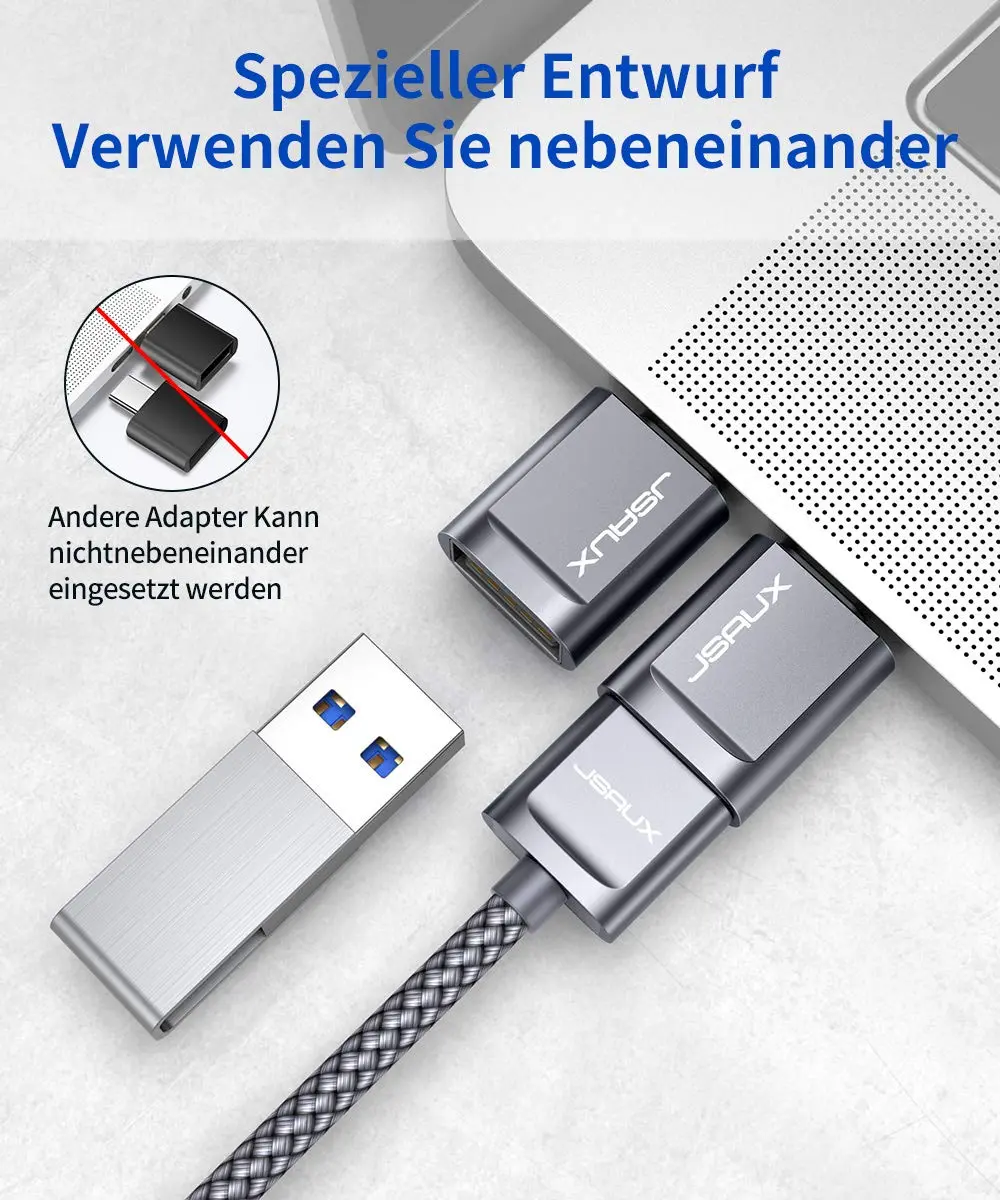 Two grey JSAUX USB-C to USB 3.0 OTG adapters plugged side-by-side into a MacBook Pro, demonstrating the offset design that allows simultaneous use with fast 5Gbps data transfer.